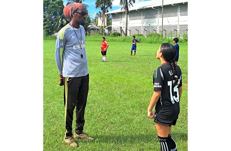 Coach Troy Wright discussing tactics with Ella Fernandes at the YMCA Ground