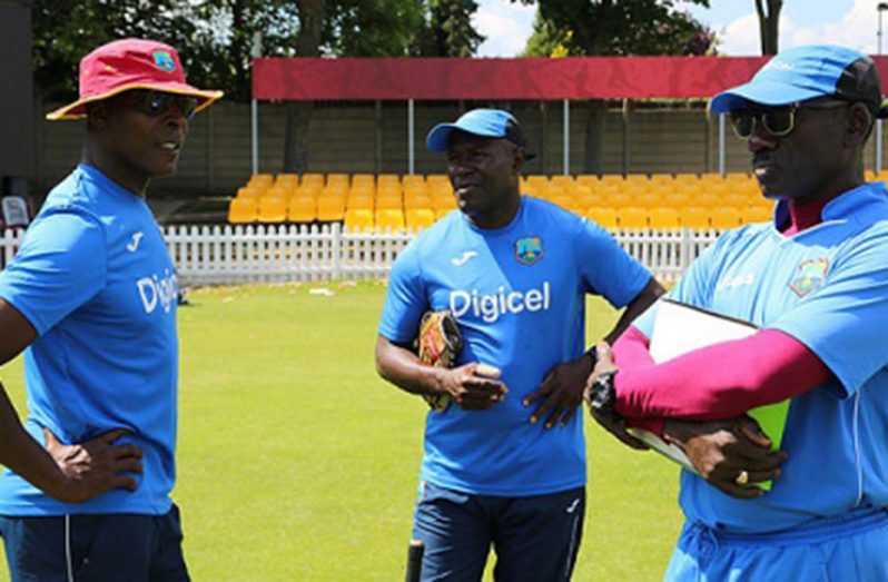 Assistant coach Stuart Williams (centre) chats with head coach Vasbert Drakes (left) and assistant coach Ezra Moseley during training. (Photo courtesy CWI Media)