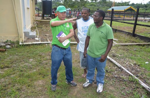 Minister of Social Cohesion, Dr. George Norton interacts with two Barakara residents in the compound of the medical centre, after the workshop