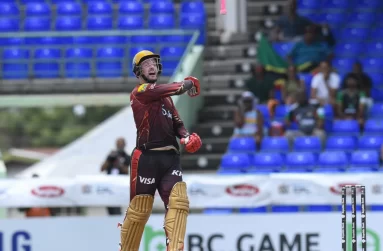 Colin Munro flips his bat up in celebration of his century (CPL T20 via Getty Images)