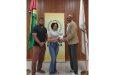 Videsh Sookram and Melitha Anderson collecting sponsorship from GOA president Godfrey Munroe