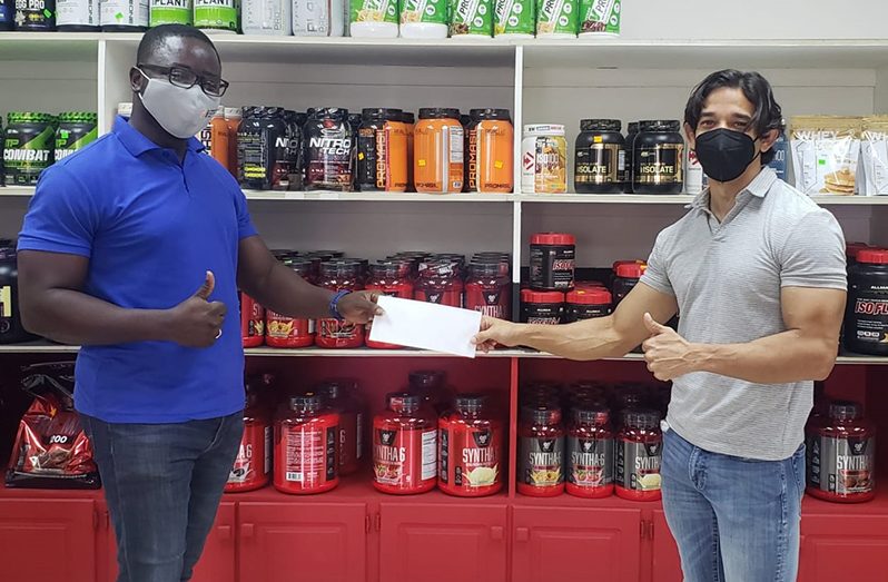 President of the GBBFF Keavon Bess (left) collects sponsorship cheque from proprietor of Fitness Express, Jamie McDonald.  The presentation was made last week.