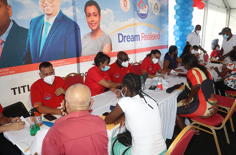 Minister of Housing and Water Collin Croal and CH&PA staff on Friday assisting persons who visited the Providence Stadium with queries pertaining to the sector (OP Photo)