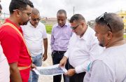 Minister of Housing and Water, Collin Croal and a team inspect a map of the area