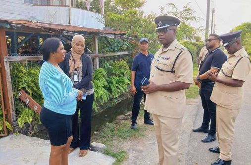 Divisional Commander, Senior Superintendent Ewart Wray, flanked by police ranks, speaks with one of the many Enterprise residents during the outreach