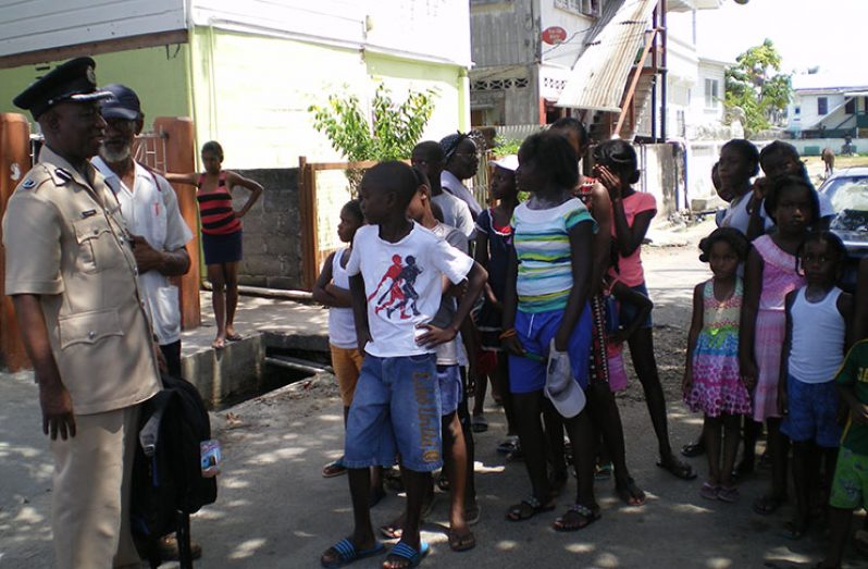 Commander Chapman having a conversation with some of the youths before distributing school supplies