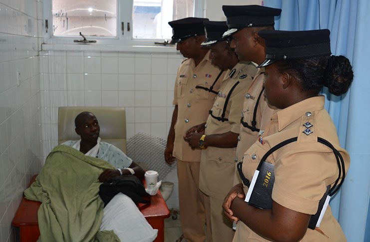 From right, standing: Acting Welfare Officer, Assistant Superintendent Jewel Sullivan; Public Relations Officer, Superintendent Jairam Ramlakhan; Divisional Commander, Assistant Commissioner Marlon Chapman and Police Association Inspector Chairman Mohan Khan, interacting with injured Police Constable Wilfred France