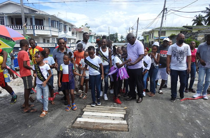 Home Affairs Minister Robeson Benn and acting Commissioner of Police, Clifton Hicken, with youths at the commissioning of the Back Circle Recreation Square in East Ruimveldt on Sunday