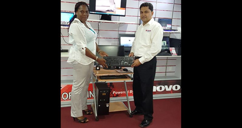 Coordinator of the Tiger Bay Project, Balinda Beckles, formally receives the desktop computer and accessories from Rehman Majeed, General Manager of STARR Computer