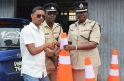 Businessman Retesh Singh of Bardon Construction Services, Traffic Chief, Superintendent Linden Isles and Deputy Commissioner (Operations) Maxine Graham during the formal handing over of the cones
