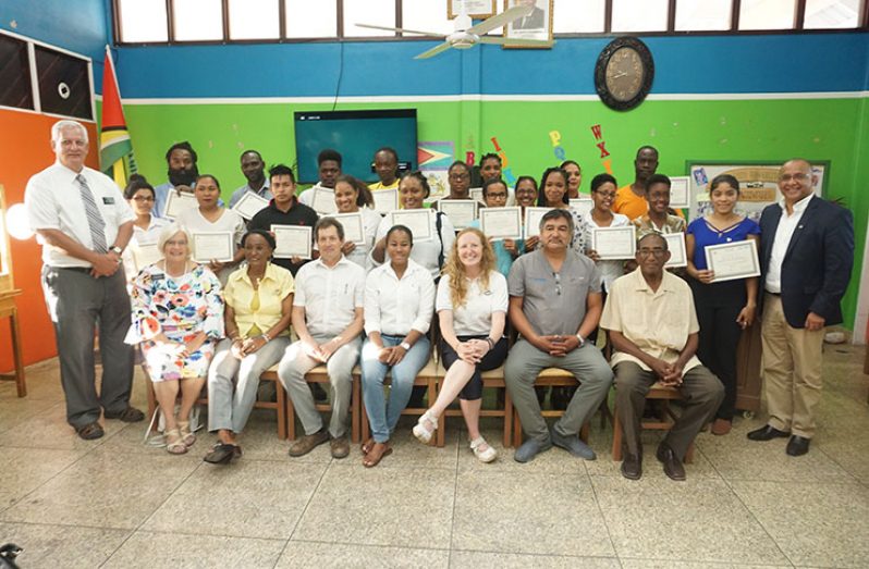 The persons who benefitted from the capacity-building training display their certificates in the presence of the training consultants and staffers of the Ptolemy Reid Rehabilitation Centre (Carl Croker photo)