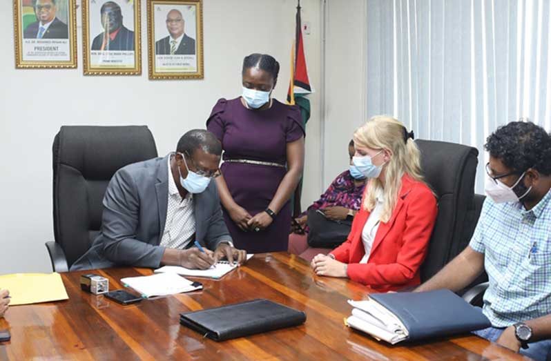 Director-General of the Maritime Administration Department, Stephen Thomas, signs the contract as Koole Contractors’ representative, Janneke Kuijper and Ministry of Public Works Permanent Secretary, Vladim Persaud look on (DPI photo)