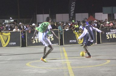 In this Sonell Nelson photograph, West Back Road’s Akeem ‘Too Cute’ Fitzpatrick (with ball) controls the flow of play for his team in their first round encounter against defending champions Queen Street-Tiger Bay.