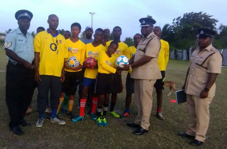 C-Division Commander, Senior Superintendent Edmond Cooper, hands over the balls to the Victoria Youth Club.