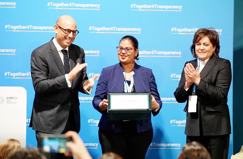 Senior Director of Climate and REDD+ at the Ministry of Natural Resources, Pradeepa Bholanath (centre), receives an award recognising Guyana’s commitment to transparent climate reporting from UNFCCC Executive Secretary, Simon Stiell (left), alongside another official