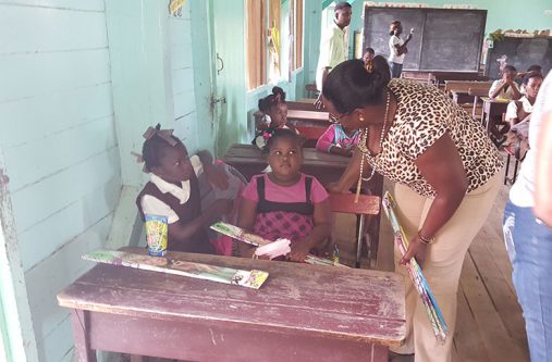 Minister within the Ministry of Natural Resources, Simona Broomes, shares a light moment with two little girls on Friday during her kite-distribution exercise on the Corentyne.