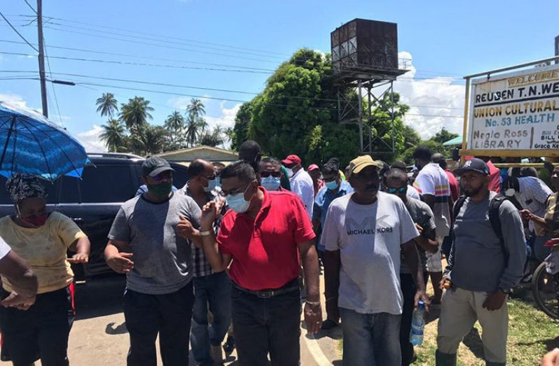 Minister Mustapha and team make
their way to assess the drainage issue in Number 53 Village