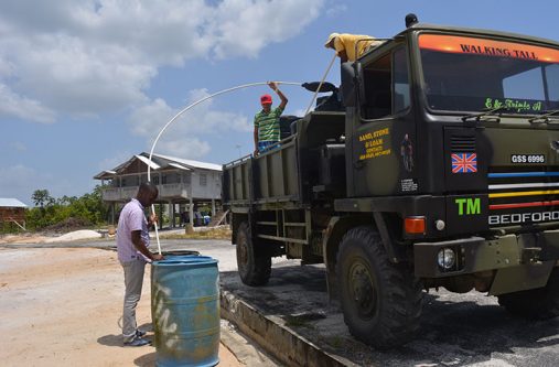 Council Mayor of Bartica, Gifford Marshall assisting a team in distributing water to the affected residents