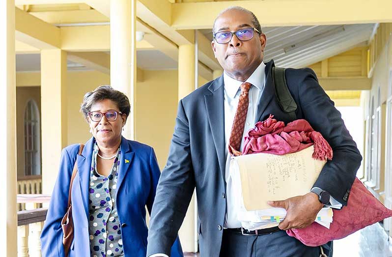 Attorney Nigel Hughes alongside his wife, Catherine, at the High Court in Georgetown on Thursday