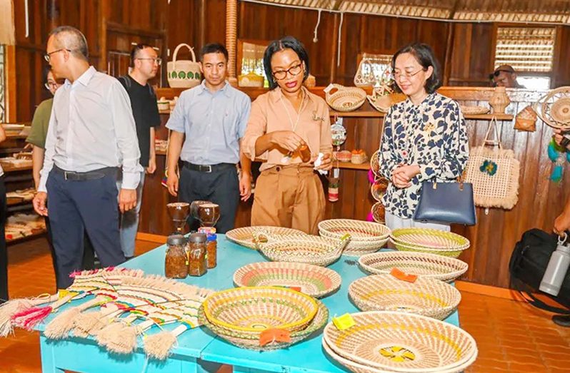 Minister of Tourism, Industry, and Commerce, Oneidge Walrond (left) and Chinese Ambassador to Guyana, Guo Haiyan, admire intricate Amerindian straw craft, woven with tradition and skill, reflecting the rich cultural heritage of Guyana’s indigenous communities