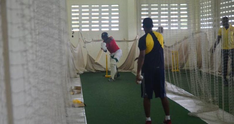 Berbice’s middle order batsman Royston Crandon (red) pushes confidently at a delivery that was thrown to him by Berbice Cricket Board head coach Julian Moore, at the Chetram Singh Centre of Excellence yesterday afternoon. (Photo by Adrian Narine)