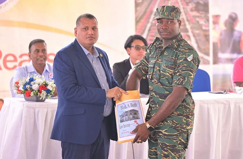 Minister of Housing and Water, Collin Croal, and a member of the Guyana Defence Force at the ‘Dream Realised’ housing drive in Region Five