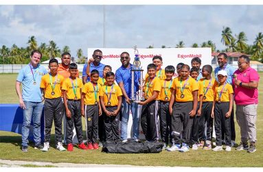 Cropper Primary School with the championship trophy alongside members of the oganising team, FL Sport, and officials from ExxonMobil Guyana