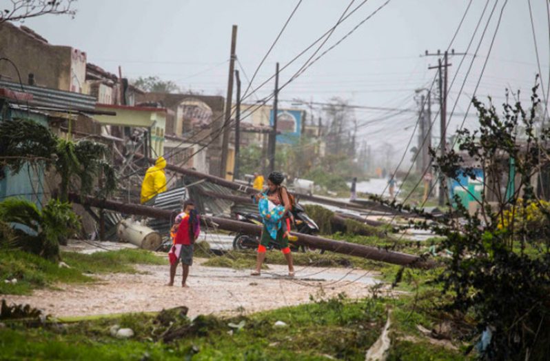 Residents picking their way around downed power lines in Caibarien on Saturday