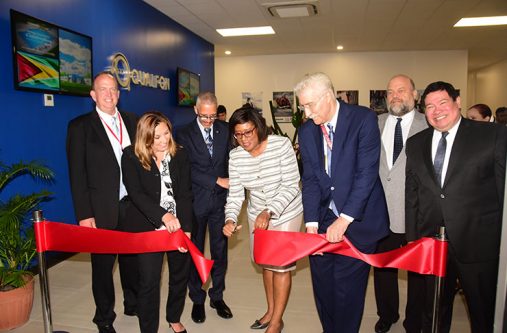 Qualfon's President, Christine Morris and Minister of Telecommunications, Cathy Hughes cut the ribbon to Qualfon’s Campus Two building while Minister Dominic Gaskin, US Ambassador Perry Holloway, Mexico's Ambassador to Guyana, Ivan Roberto Sierra-Medel and Qualfon executives look on