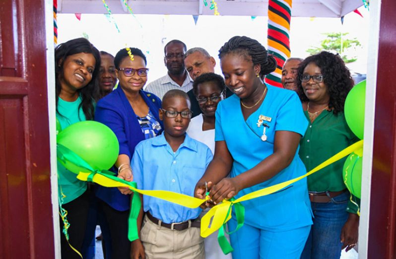 Public Health Minister, Volda Lawrence, assists a student of the St. John the Baptist Primary School and Senior Nurse Carrol Samuels to cut the ribbon to officially reopen the expanded A&E Unit at the Bartica Hospital (DPI photo)