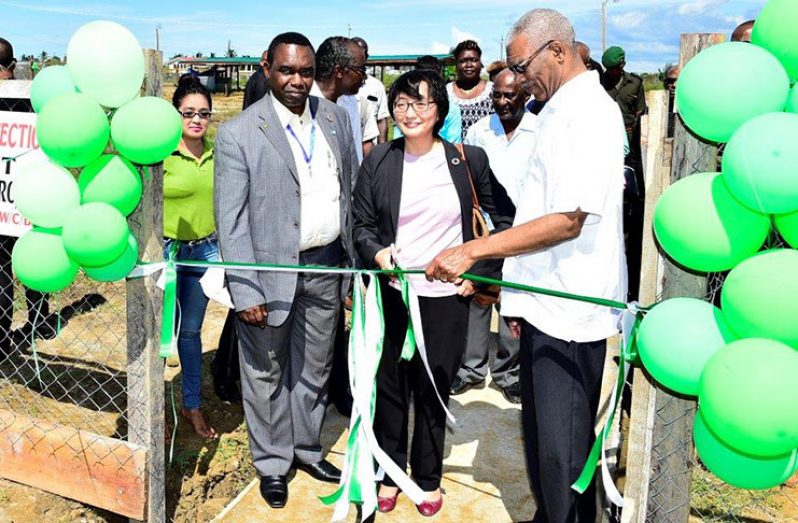 United Nations (UN) Resident Coordinator Mikiko Tanaka (centre) cuts the ribbon to launch the project. Looking on are representative of the Food and Agriculture Organisation (FAO) Reuben Robertson (at left) and President David Granger