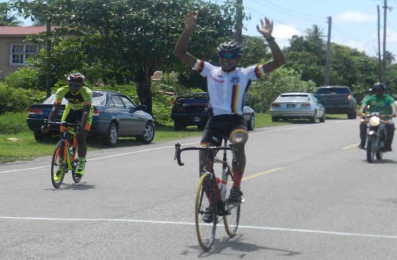 Christopher Griffith raises his hands as he crosses the finish line.