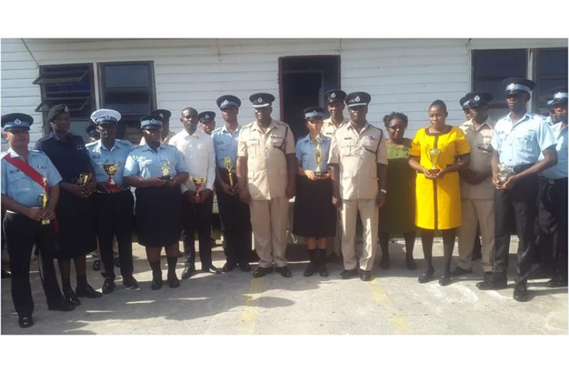 (Standing in the middle in front) 

Commander Edmond Cooper and his Deputy Dion Moore flanked by some of the awardees within the division.
