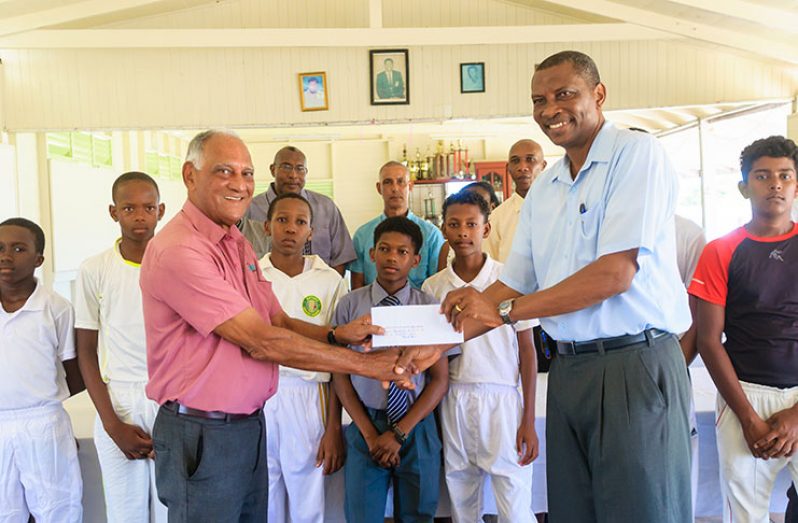 GCA president Roger Harper (right) collects the sponsorship from Toucan Distributors’ Lenny Shuffler for the GCA U-15 league. In the background are several U-15 participants and GCA executives. (Delano Williams photo)