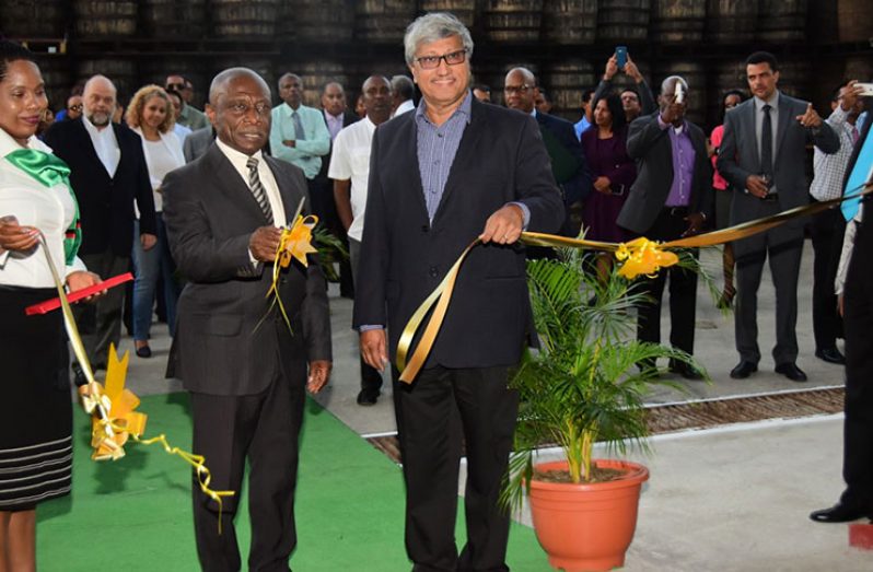 Acting Prime Minister and Minister of Foreign Affairs, Carl Greenidge shares the honour with DDL Chairman, Komal Samaroo of cutting the ceremonial ribbon to formally declare open the beverage company’s new warehouse facility at Diamond (Photo by Adrian Narine)