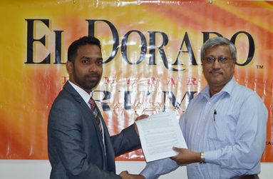 Trevor Bassoo, Guyana Amazon Warriors Marketing and Sponsorship Manager (left) holds the signed contract with Komal Samaroo, Demerara Distillers Limited Executive Chairman.