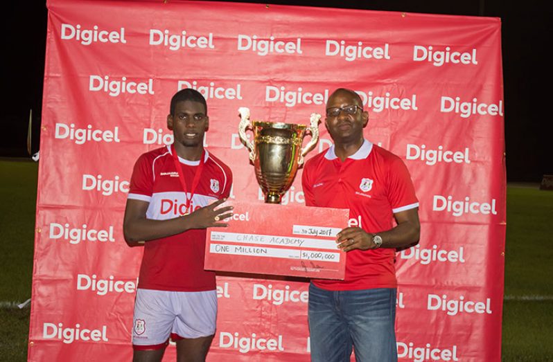 Digicel’s Regional CEO Gregory Dean (right) makes the presentation to Chase Academy Captain Jeremy Garrett.