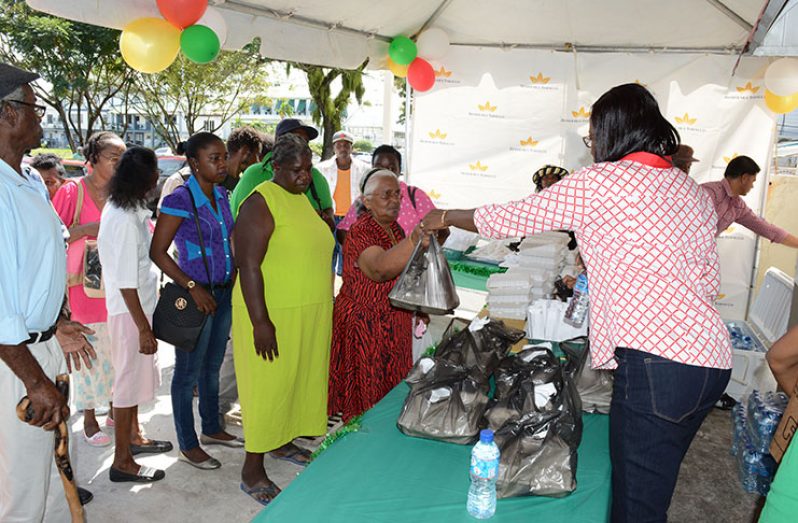 Demtoco’s Ms Maurlaine Argyle-Kirton assisting with the sharing of lunches to the less fortunate