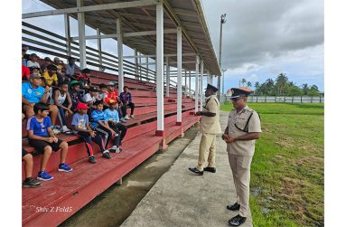 Regional Commander No. 6, Assistant Commissioner of Police Shivpersaud Bacchus watches on as Deputy Superintendent Newland makes a point during the interaction with the students