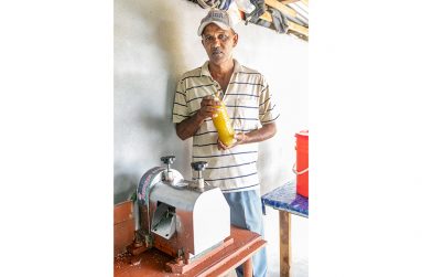 Deochand Ramdatt displaying a bottle of freshly milled sugarcane juice at his home (Delano Williams photos)