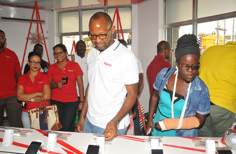 Digicel’s CEO Gregory Dean and a customer check out some of the handsets on sale