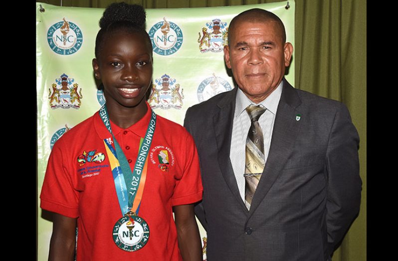 Minister of Social Cohesion, Dr George Norton (right) and South American Youth Games gold medallist Deshanna Skeete. (Adrian Narine photo)