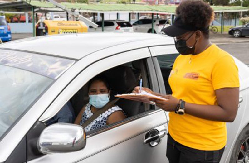 This woman registers for her COVID vaccine from the comfort of her car at the inaugural COVID-19 vaccination drive-through exercise at the Providence Stadium (DPI photo)