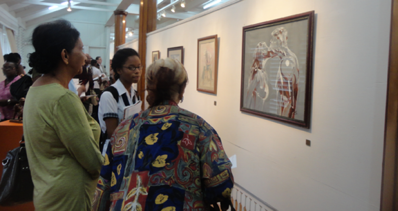 Visitors to the “The Tutors Exhibition” contemplate “Kissed” (2004), a Nicole Bissoo-Williams acrylic painting