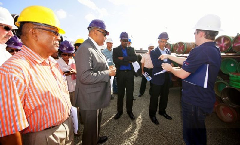 Minister of Natural Resources, Mr. Raphael Trotman, Minister of Public Infrastructure, Mr. David Patterson,  Minister of Business, Mr. Dominic Gaskin, and other representatives pay keen attention to an ExxonMobil’s representative, during a tour of the oil company’s storage facility at the Wieting & Richter Wharf.