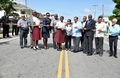 Prime Minister Moses Nagamootoo and his wife, Mrs. Sita Nagamootoo (fifth and sixth from right) are given assistance as they cut the ribbon to commission US $46M Fourth Road Project in July 2018. Also pictured are Minister of Public Infrastructure, Mr. David Patterson (third from right), Director General of the Ministry of the Presidency, Mr. Joseph Harmon, who was then Minister of State; Minister within the Ministry of Communities, with responsibility for housing, Ms. Annette Ferguson, who was then Minister within the Ministry of Public Infrastructure; and Minister of Finance, Mr. Winston Jordan. 