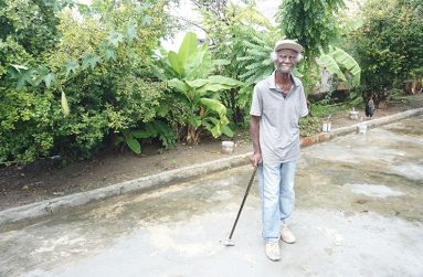 Joseph Greenville in his yard among his fruit trees