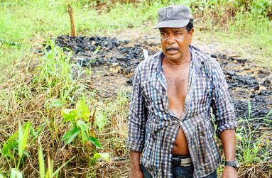 Milton Kallicharran cleaning the drain outside his home