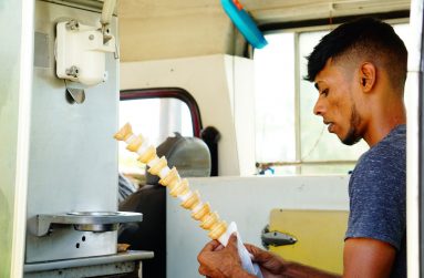 The assistant, Kevin Manmuthoo wrapping the cones with tissues before selling