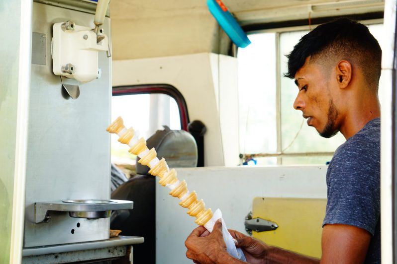 The assistant, Kevin Manmuthoo wrapping the cones with tissues before selling